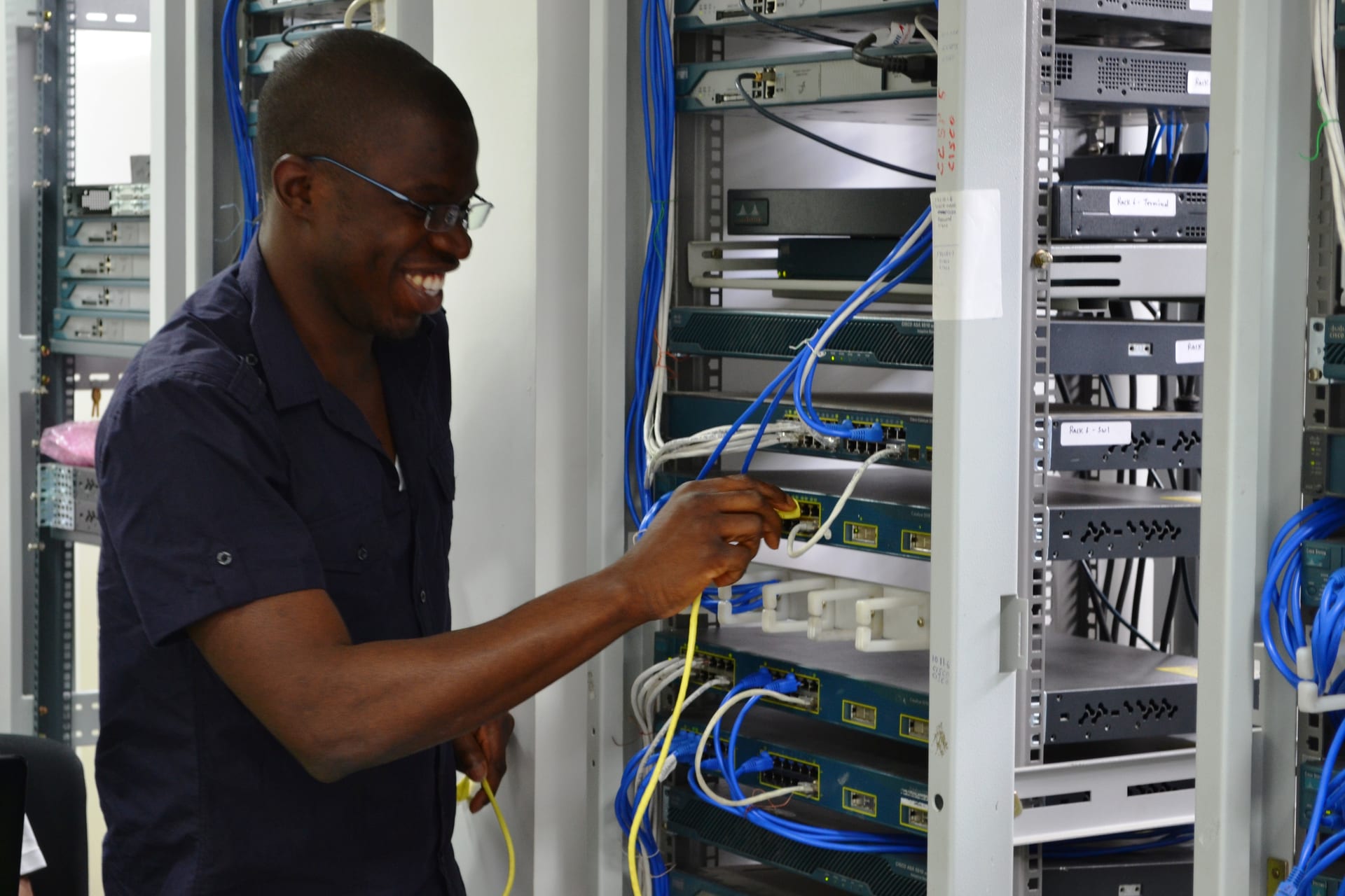Student doing hands-on Cisco rack cabling